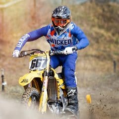 dirt bike rider in blue mx gear riding on a track