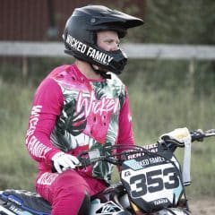 MX rider in pink gear resting between laps